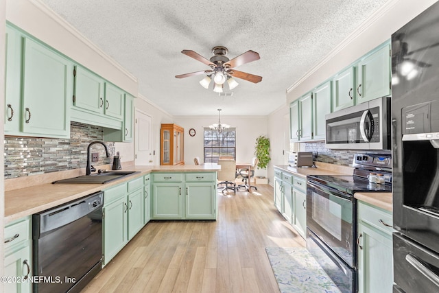 kitchen with black appliances, sink, ornamental molding, green cabinets, and kitchen peninsula