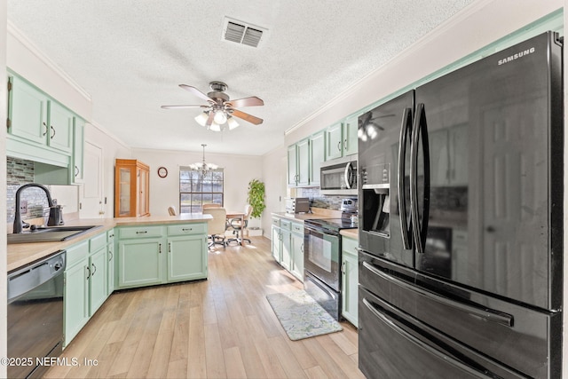 kitchen with sink, crown molding, backsplash, black appliances, and light wood-type flooring