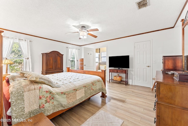 bedroom with crown molding, ceiling fan, light hardwood / wood-style floors, and a textured ceiling