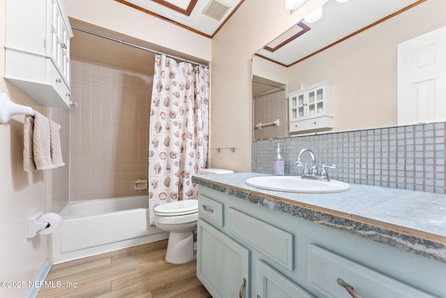 full bathroom with hardwood / wood-style flooring, tasteful backsplash, vanity, shower / bath combination with curtain, and toilet