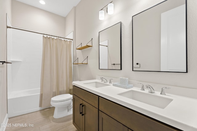 bathroom with double vanity, a sink, toilet, and shower / tub combo with curtain