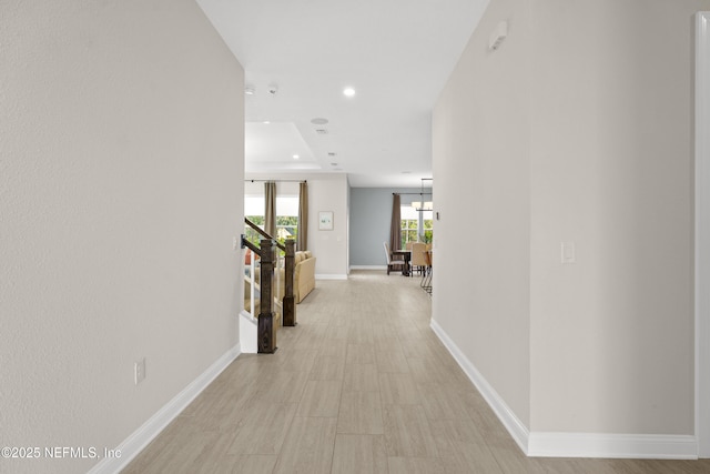 hall with recessed lighting and baseboards