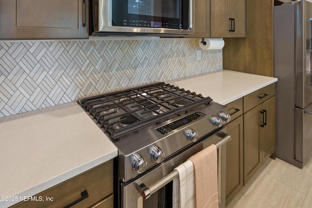 kitchen featuring decorative backsplash, stainless steel appliances, and light countertops