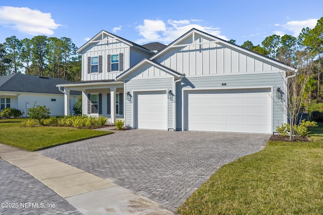 view of front of home featuring board and batten siding, decorative driveway, a front lawn, and a garage