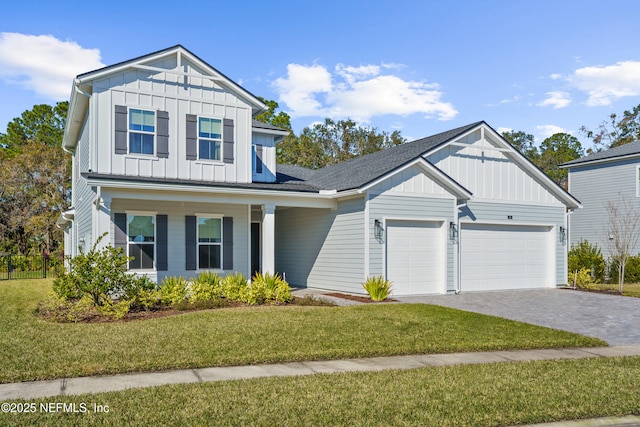 view of front facade featuring a front lawn, board and batten siding, an attached garage, and decorative driveway