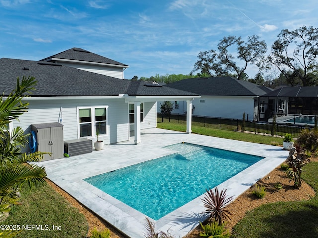 exterior space featuring a patio, a fenced backyard, a shingled roof, a lawn, and a fenced in pool