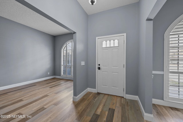 entryway featuring hardwood / wood-style flooring and a textured ceiling