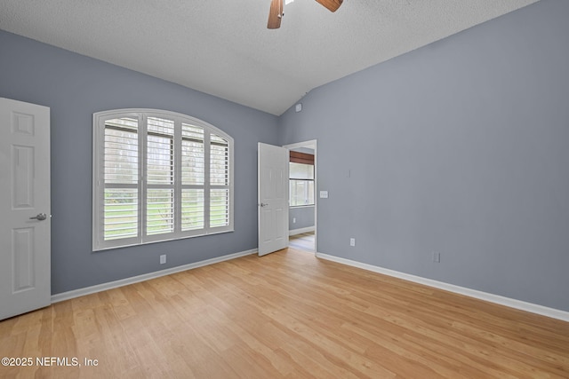 unfurnished bedroom featuring a textured ceiling, vaulted ceiling, ceiling fan, and light wood-type flooring