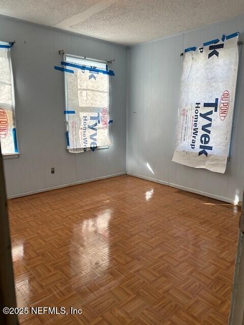 empty room featuring parquet floors and a textured ceiling