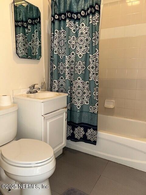 full bathroom with tile patterned floors, toilet, shower / bath combo with shower curtain, and vanity