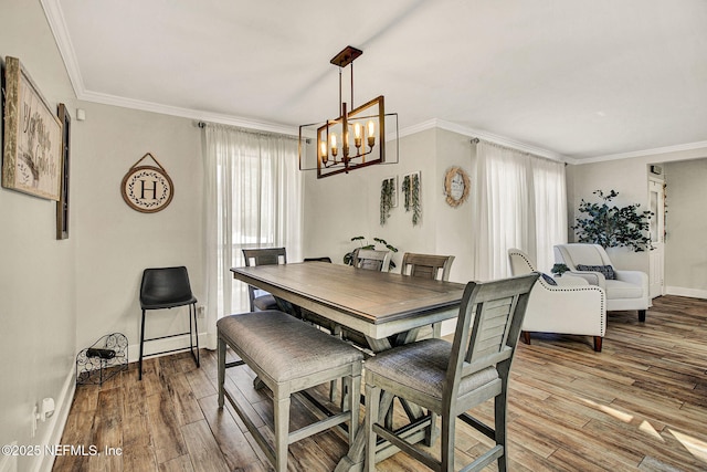 dining room with light hardwood / wood-style flooring, ornamental molding, and a chandelier