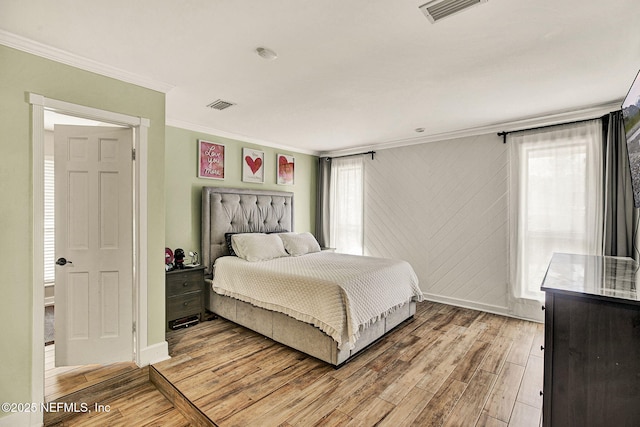 bedroom with ornamental molding and light wood-type flooring