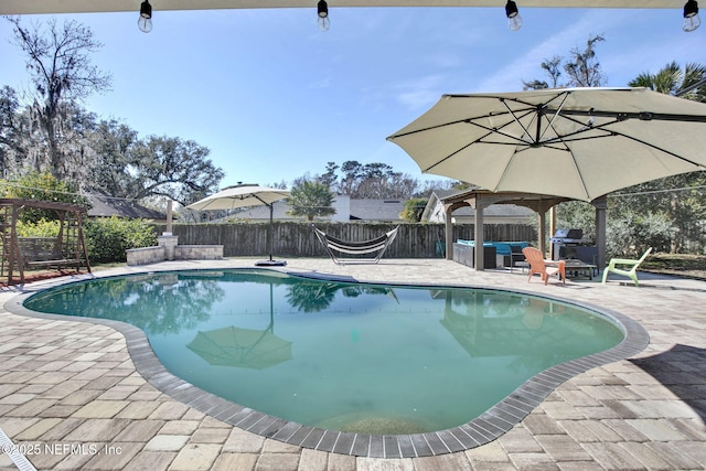 view of pool with grilling area, outdoor lounge area, and a patio area