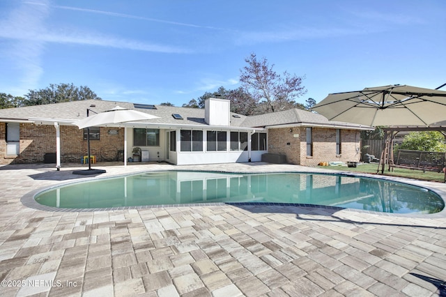 view of pool featuring a patio area and a sunroom