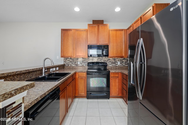 kitchen featuring tasteful backsplash, sink, dark stone counters, light tile patterned floors, and black appliances