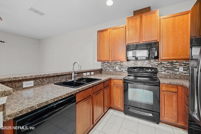 kitchen featuring light tile patterned flooring, black appliances, sink, decorative backsplash, and kitchen peninsula