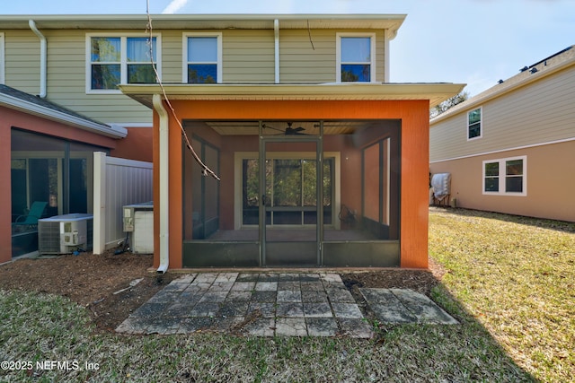 rear view of property with a lawn, a sunroom, and central air condition unit