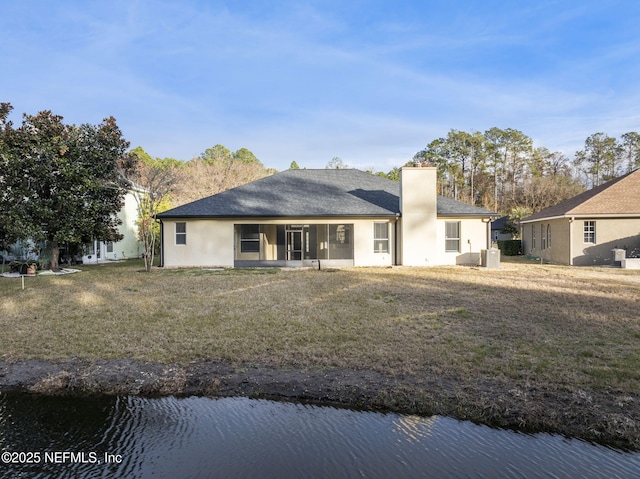 back of house featuring a water view and a yard