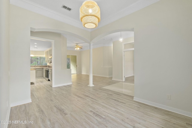 unfurnished room featuring ornate columns, ornamental molding, ceiling fan, and light wood-type flooring