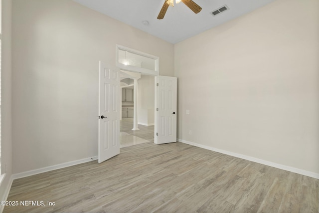 unfurnished bedroom with a towering ceiling, ceiling fan, and light hardwood / wood-style flooring