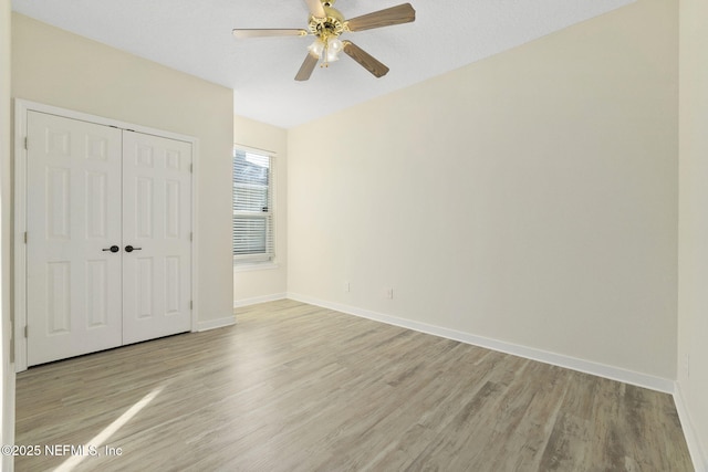 unfurnished bedroom with a closet, ceiling fan, and light wood-type flooring