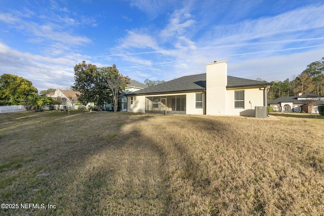 back of house featuring cooling unit and a lawn