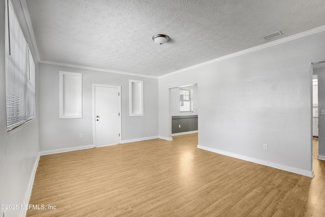 unfurnished room with crown molding, a textured ceiling, and light wood-type flooring