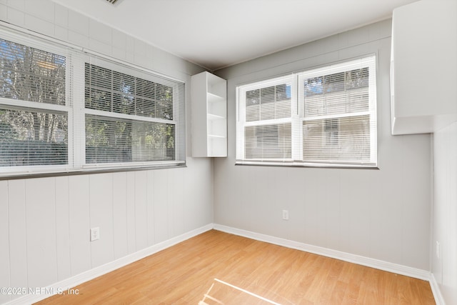 spare room with hardwood / wood-style flooring and a healthy amount of sunlight