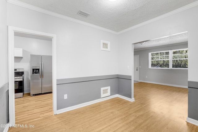 unfurnished room with ornamental molding, a textured ceiling, and light hardwood / wood-style flooring