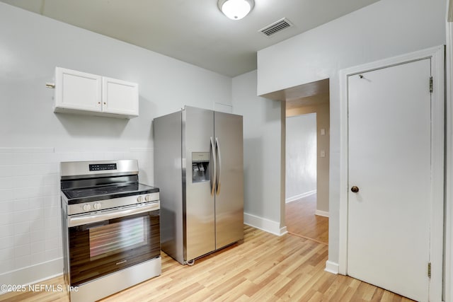 kitchen featuring white cabinetry, stainless steel appliances, and light wood-type flooring