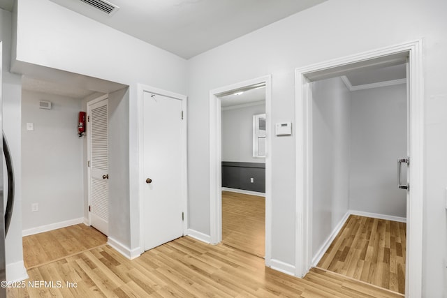 corridor featuring crown molding and light wood-type flooring