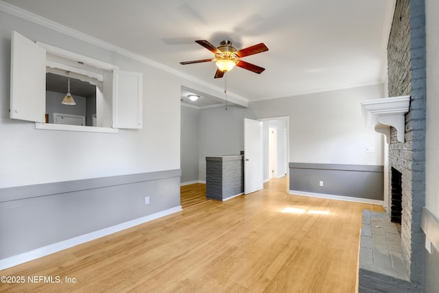 unfurnished living room featuring a brick fireplace, ornamental molding, ceiling fan, and light wood-type flooring