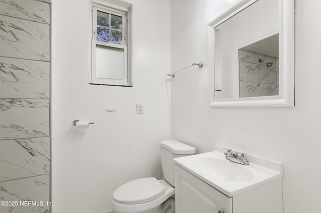 bathroom with vanity, toilet, and a shower