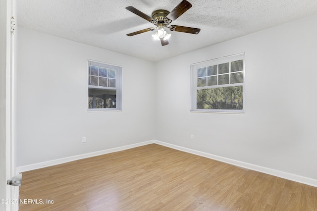 spare room with ceiling fan, light hardwood / wood-style flooring, and a textured ceiling