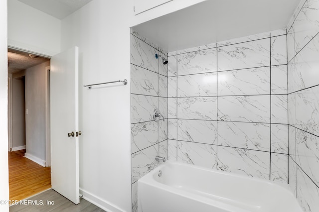 bathroom with hardwood / wood-style flooring and tiled shower / bath