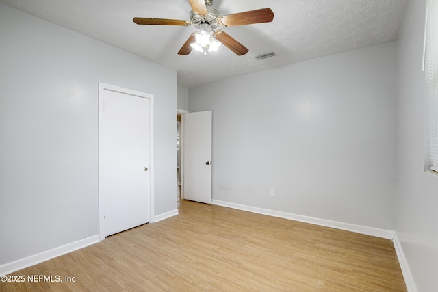 spare room featuring ceiling fan, a textured ceiling, and light wood-type flooring