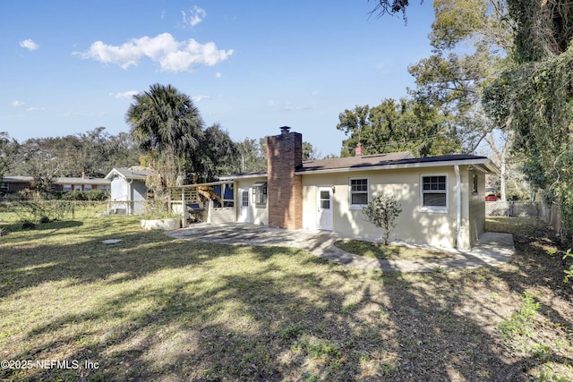 back of property with a yard and a patio