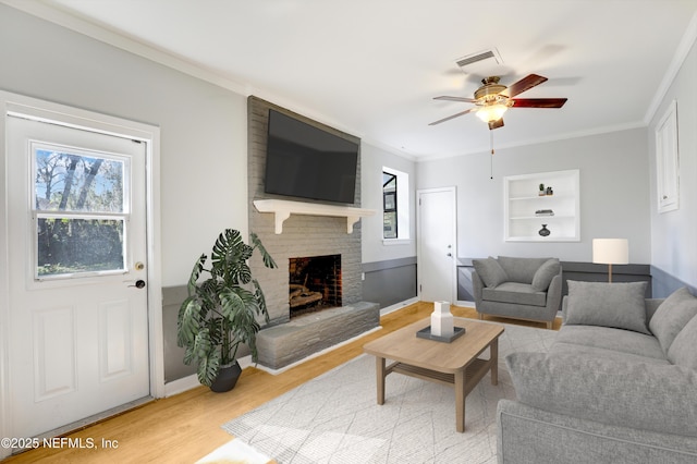 living room featuring hardwood / wood-style flooring, ornamental molding, and plenty of natural light