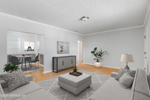 living room with ornamental molding, hardwood / wood-style floors, and a textured ceiling