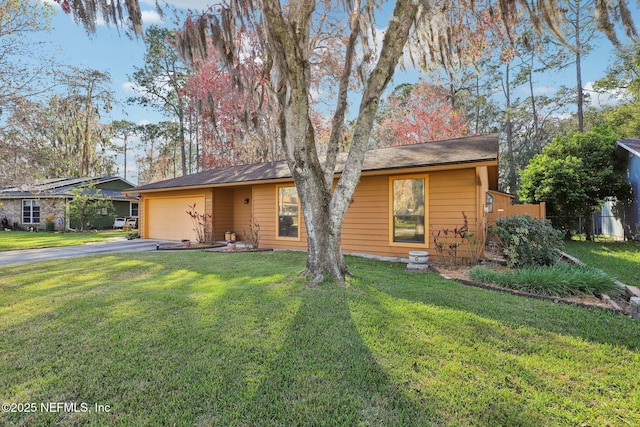 view of front of property with driveway, an attached garage, and a front lawn