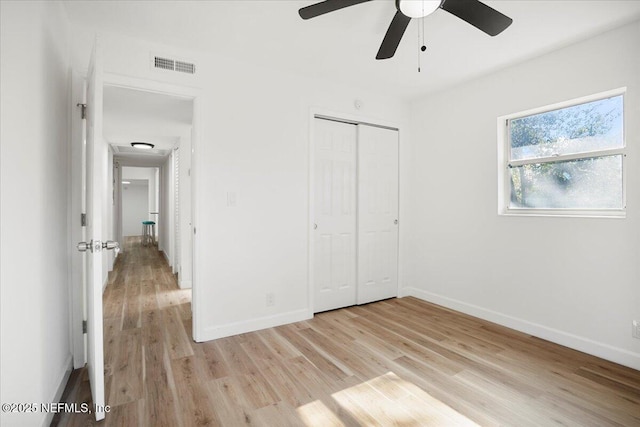 unfurnished bedroom featuring ceiling fan, a closet, and light hardwood / wood-style flooring