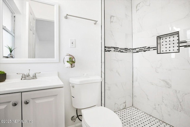 bathroom featuring vanity, tiled shower, and toilet