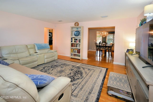 living room featuring a notable chandelier and light hardwood / wood-style floors