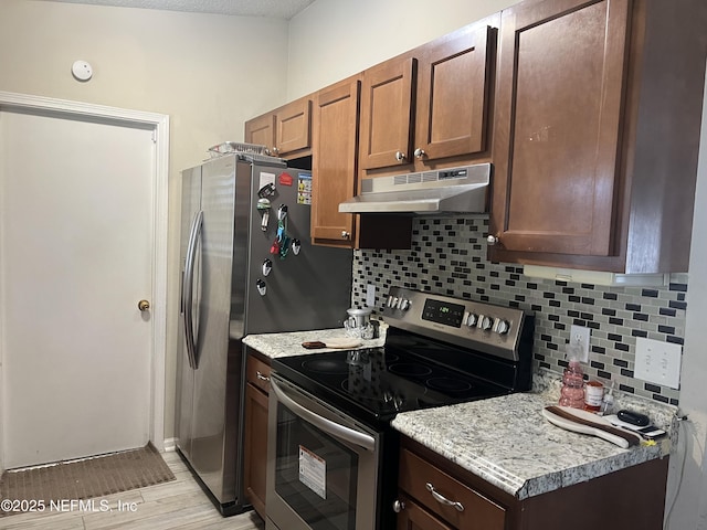 kitchen with stainless steel range with electric stovetop, decorative backsplash, and light stone countertops