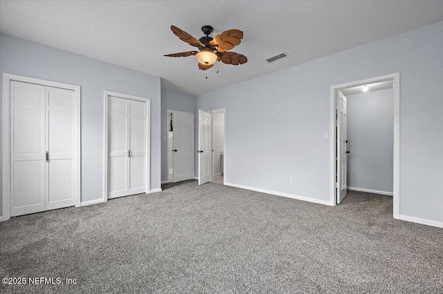 unfurnished bedroom with multiple closets, ceiling fan, and carpet