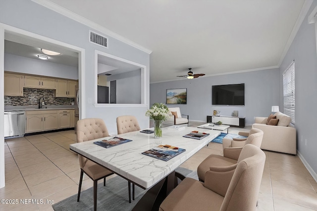 dining area with crown molding, sink, light tile patterned floors, and ceiling fan