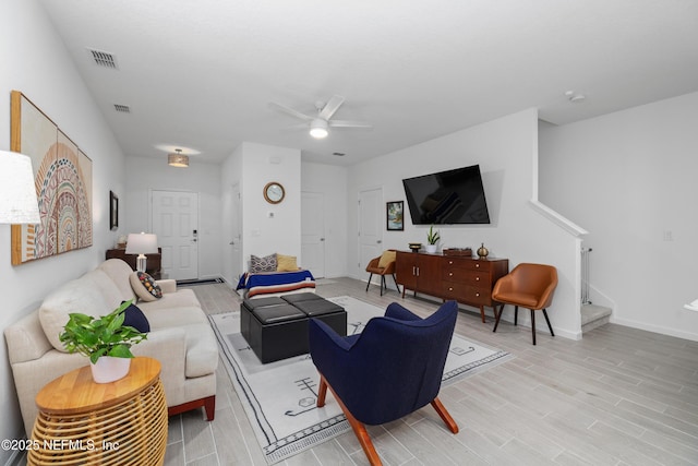 living room with ceiling fan and light hardwood / wood-style flooring