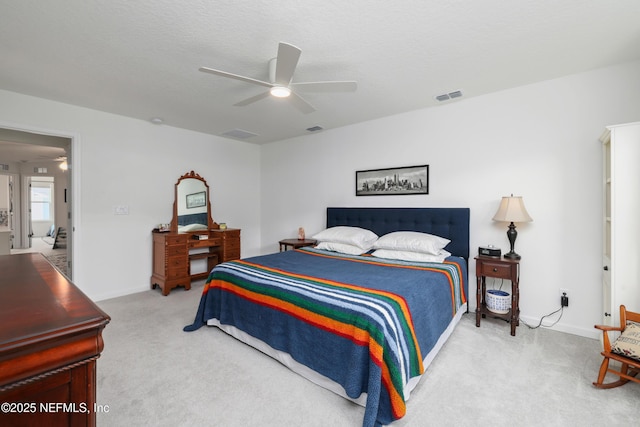 bedroom featuring light carpet, a textured ceiling, and ceiling fan