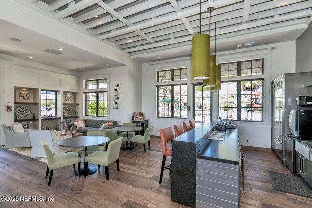 dining area featuring a towering ceiling and dark hardwood / wood-style floors