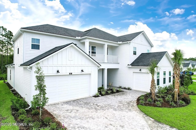 view of front of house with a garage, a balcony, and a front lawn